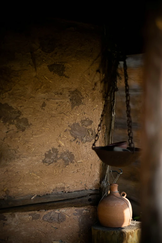 a large brown vase sits on the ledge beside a small scale