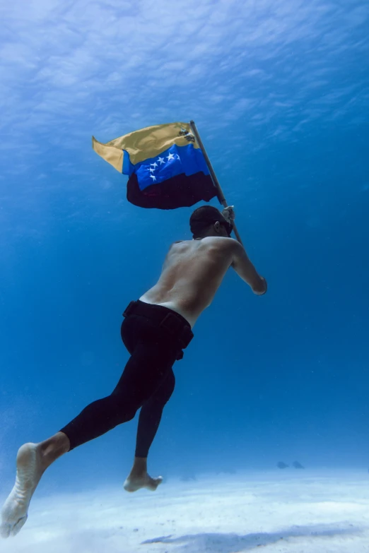 a man diving and holding a flag in the air