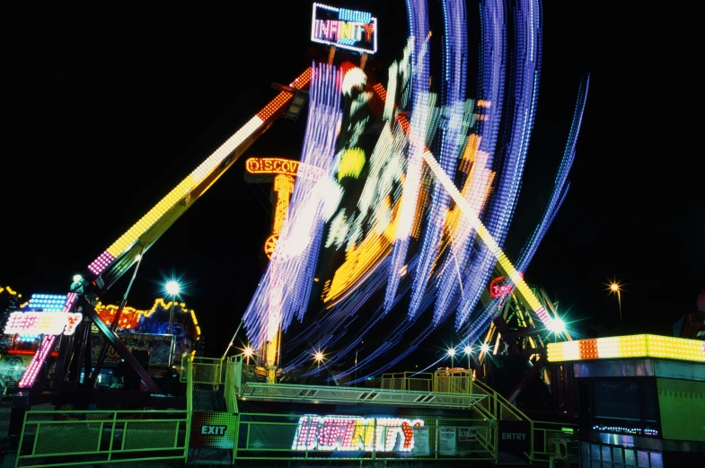 an amut park lit up with lights and carnival rides