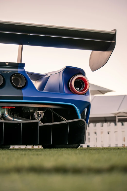 the rear end of a blue race car with chrome exhaust
