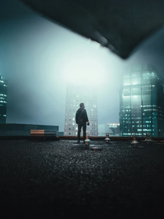 man standing alone on road in large city