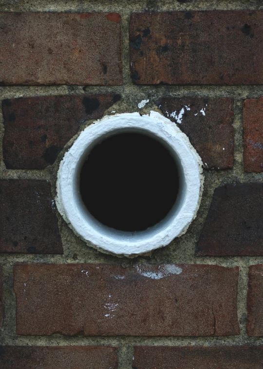 a round hole in a brick wall with paint