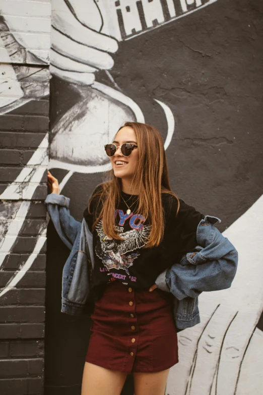 a woman standing in front of a painted wall