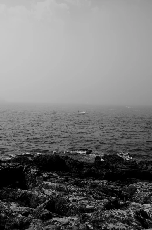 two small boats floating in the ocean on a cloudy day