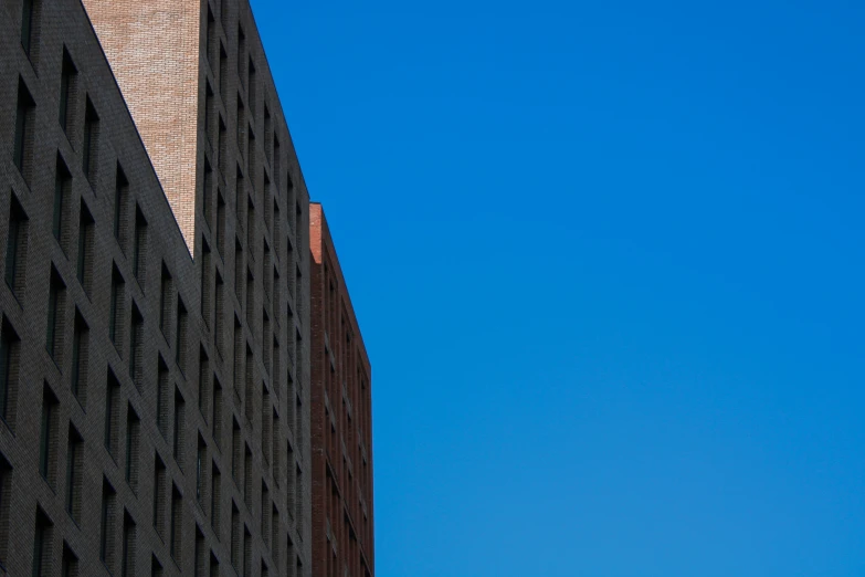 an airplane flying past a building and it's shadow on the building