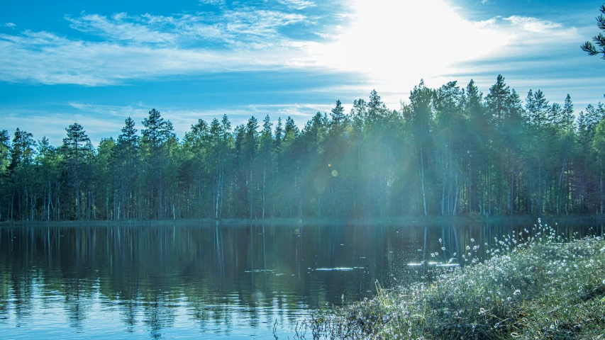 a scenic lake with sunbeams shining brightly above the water