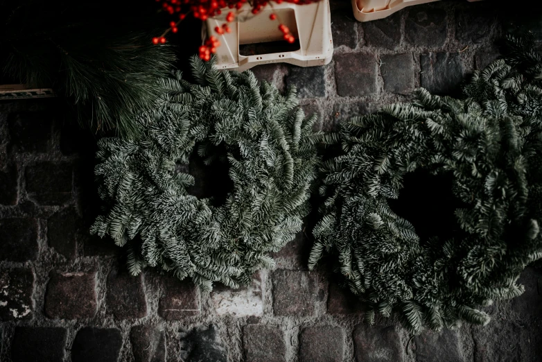 a couple of wreaths mounted on the side of a brick wall