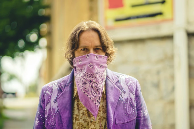 a man is covering his face with a purple cloth