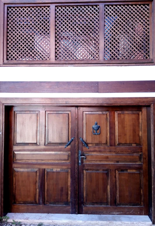 wooden door with intricately carved screens above it