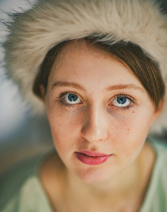 a close up view of a young woman with a messy hat