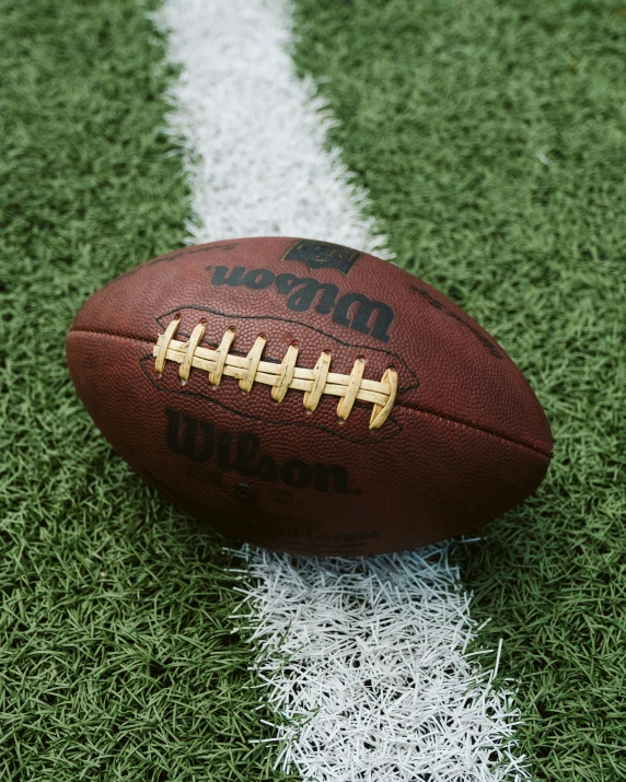 a football on the ground with a white stripe