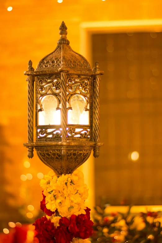 a beautiful candle and flower arrangement sits in front of the chandelier