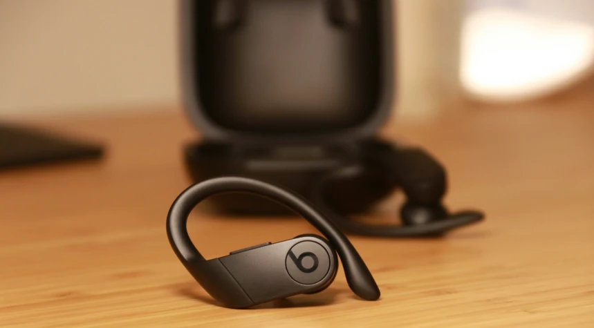 a pair of black headphones sit on a wooden surface