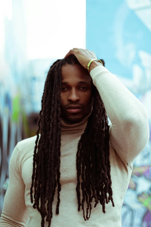 a man with a dreadlocks on and a white sweater