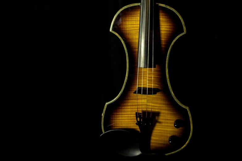 a violin lying on a black surface