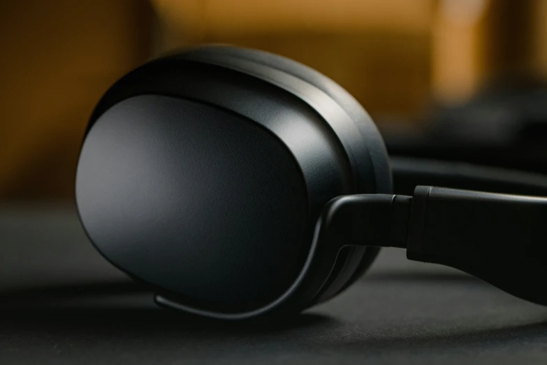 black headphones lying on top of a gray table