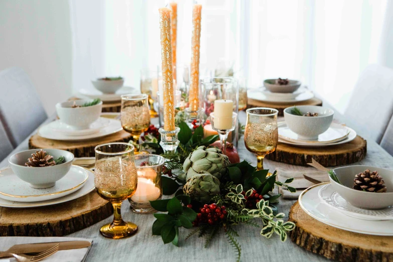 a table with white plates, silverware and flowers on it