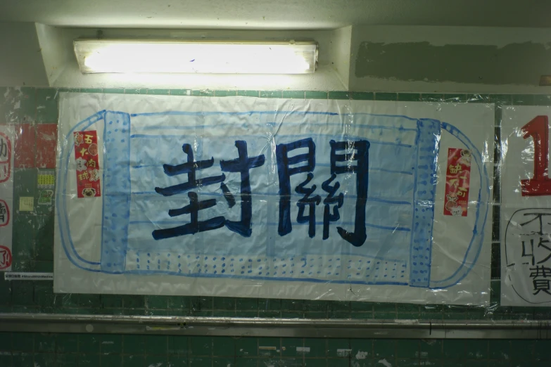 sign in the chinese language on the wall above a toilet