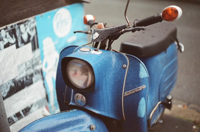 an image of a blue motor scooter with side mirror