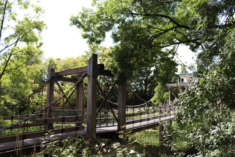 a wooden bridge over some water next to trees