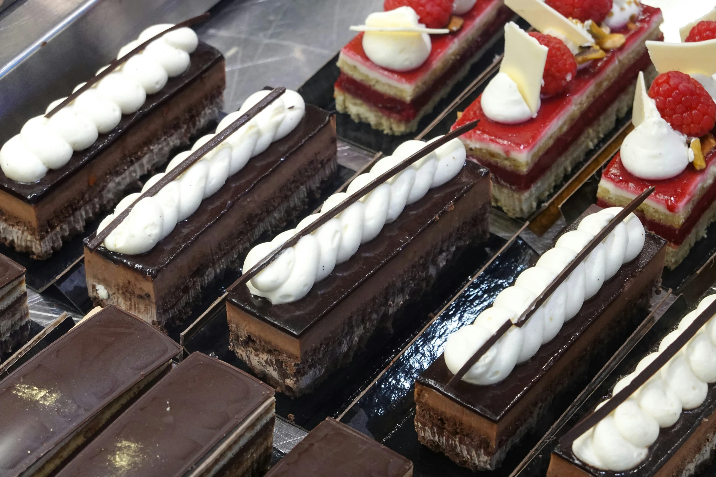 some fancy chocolates, cake and desserts are sitting on a shelf