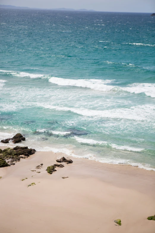 a sandy shore that has waves coming in to shore