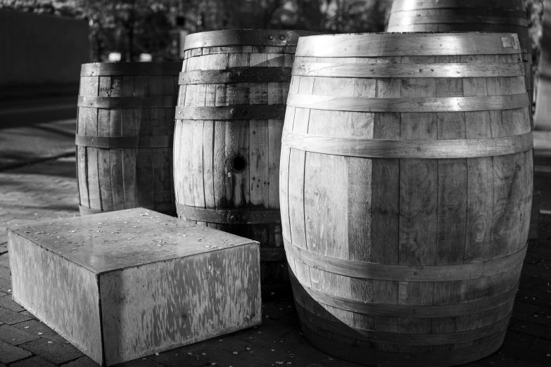 several wooden barrels with faces are in front of a brick sidewalk