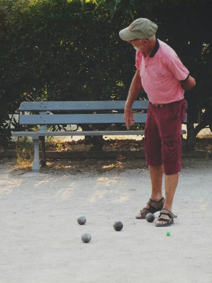 an older man is playing with his bowling balls