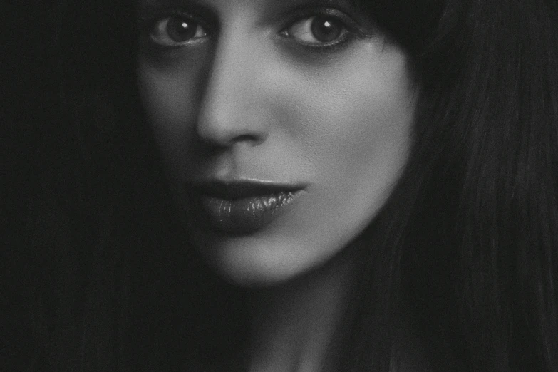 a woman with long hair looking into the camera