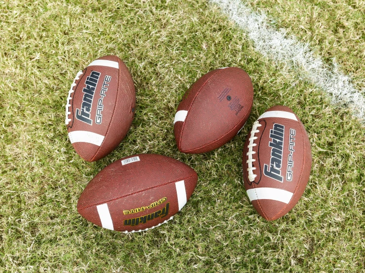 an overhead view of three footballs in a row on the field