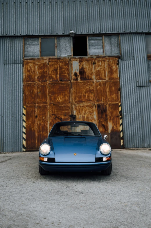 blue sports car parked in front of a building