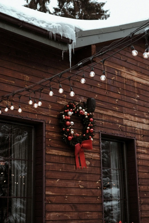 a christmas wreath is hung on a cabin wall