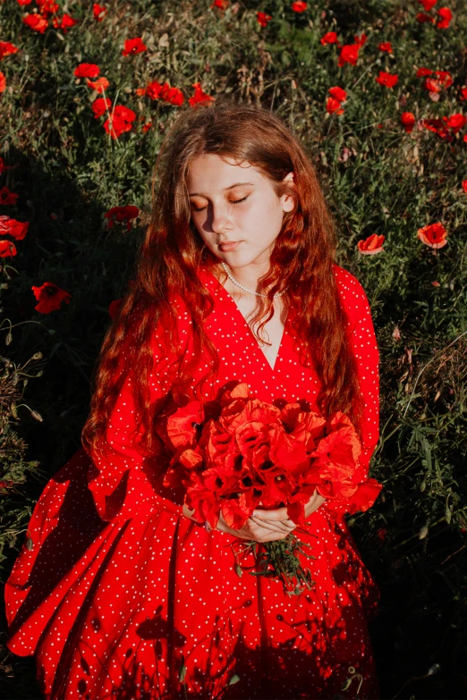 a woman in a red dress and holding a bouquet of flowers