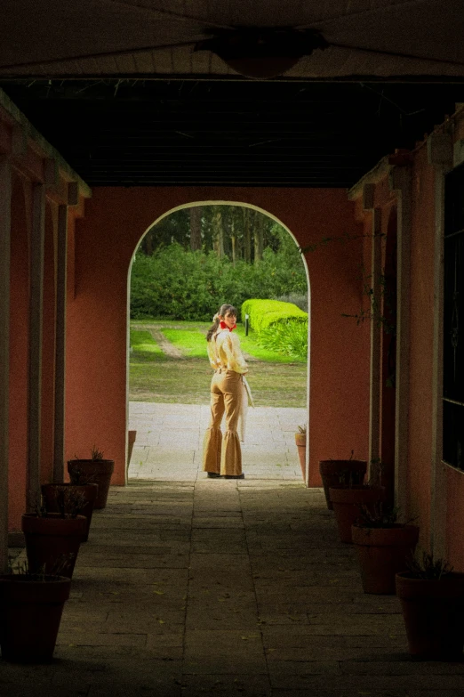 woman in dress standing at the doorway of a building