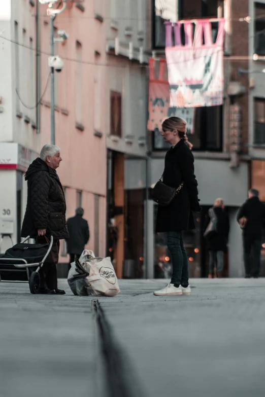 a woman standing next to an older man holding a hand bag