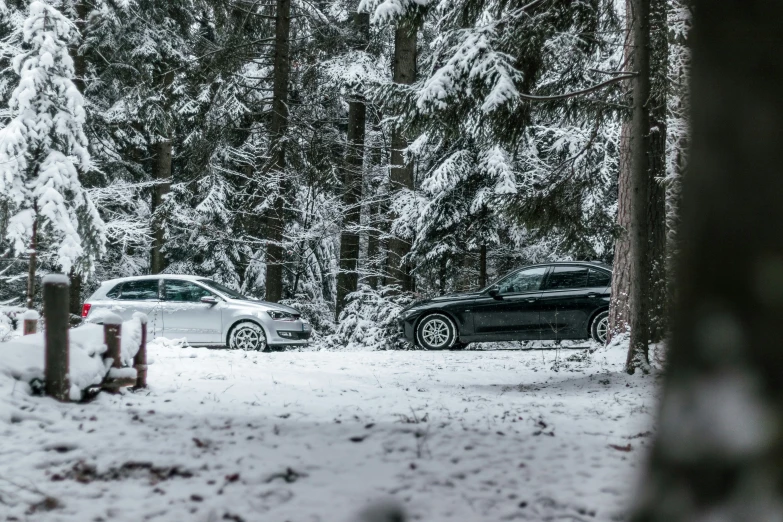 two vehicles parked on the side of a road covered in snow