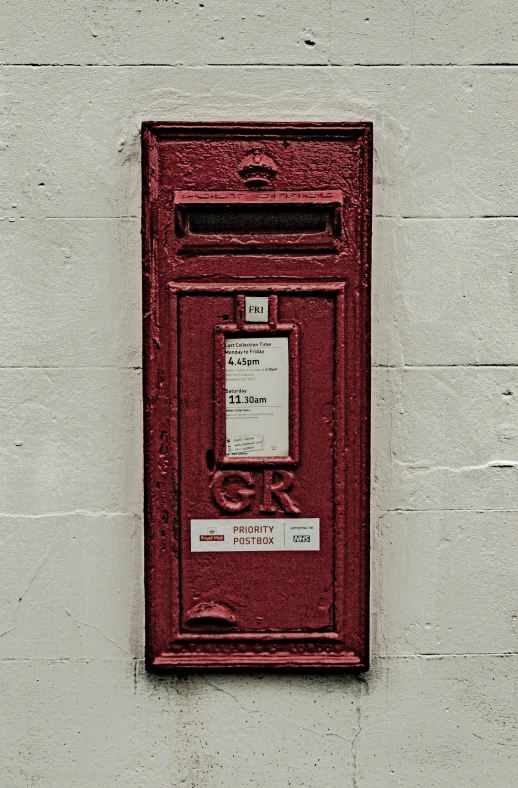 a close - up of an old style mailbox, against a wall