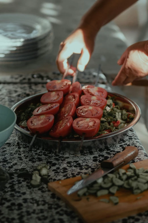 a plate of sliced up tomatoes and potatoes on a table