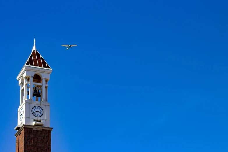 a plane in the sky behind a tower