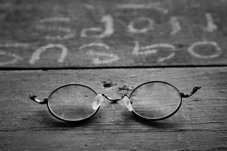 a pair of glasses lying on a wooden table