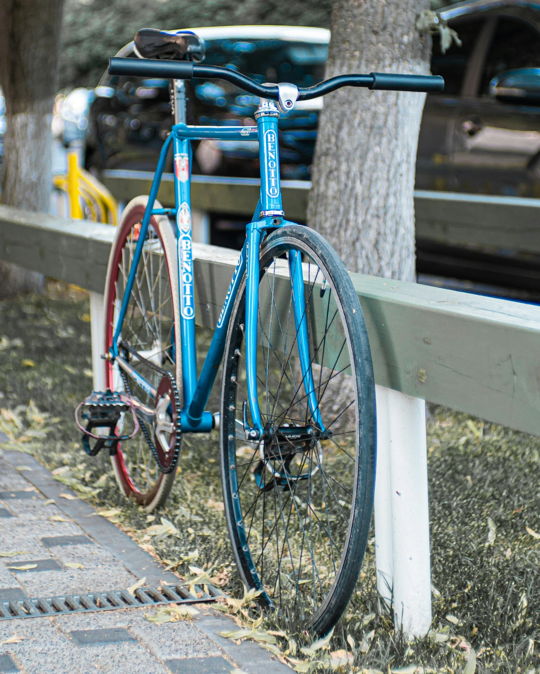 blue bicycle propped up against the side of a wooden fence