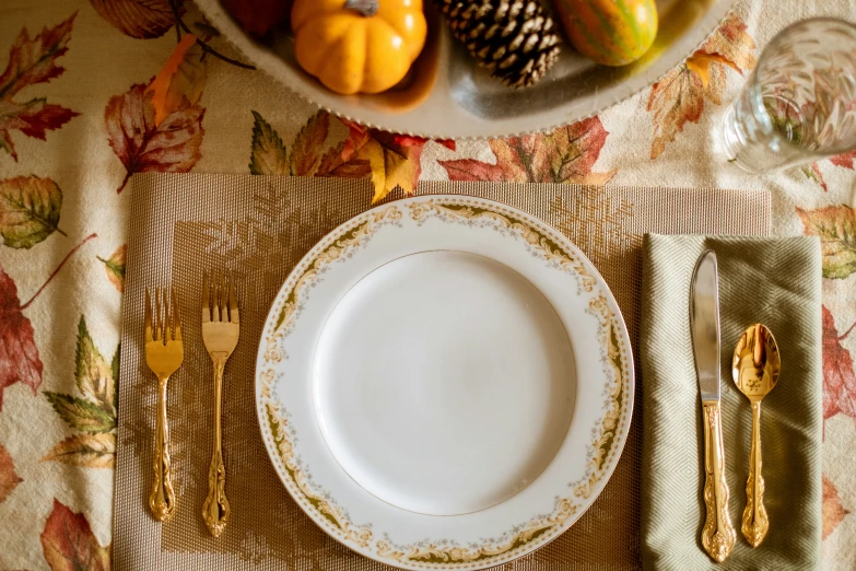 an elegant table setting with white plates and gold utensils