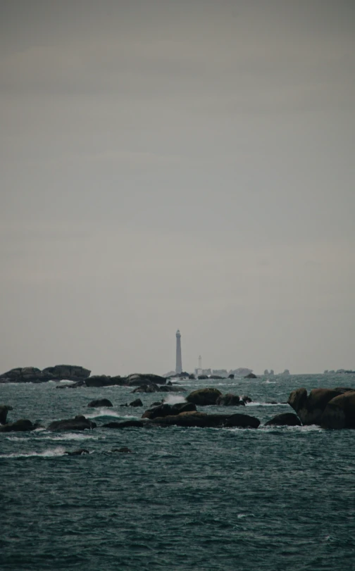 the lighthouse stands alone in the middle of a body of water