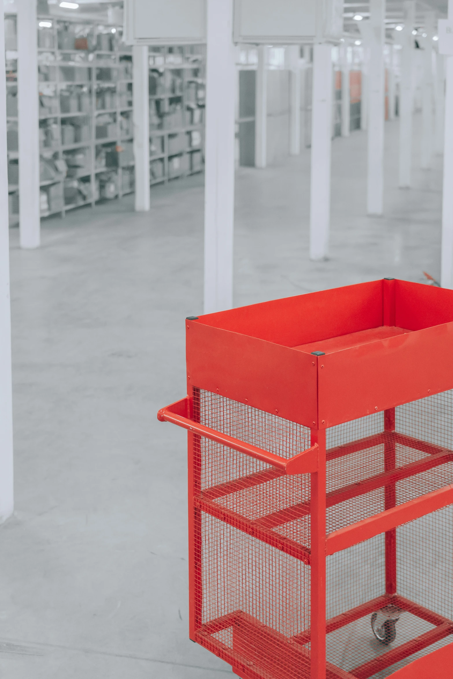 an orange container in a large building with many shelves