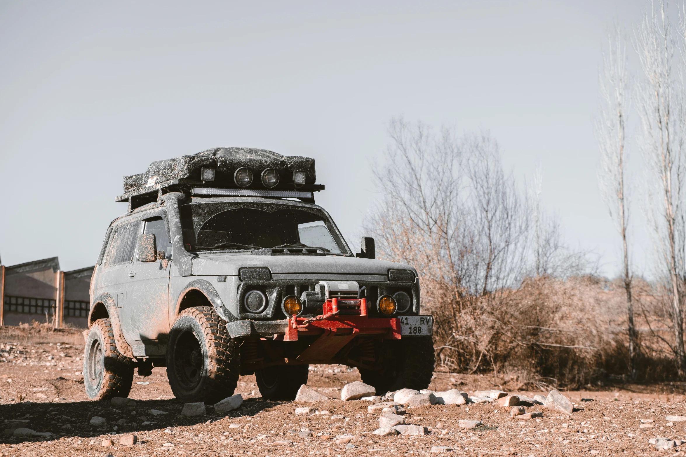 an off road vehicle with a black top and red cargo trailer