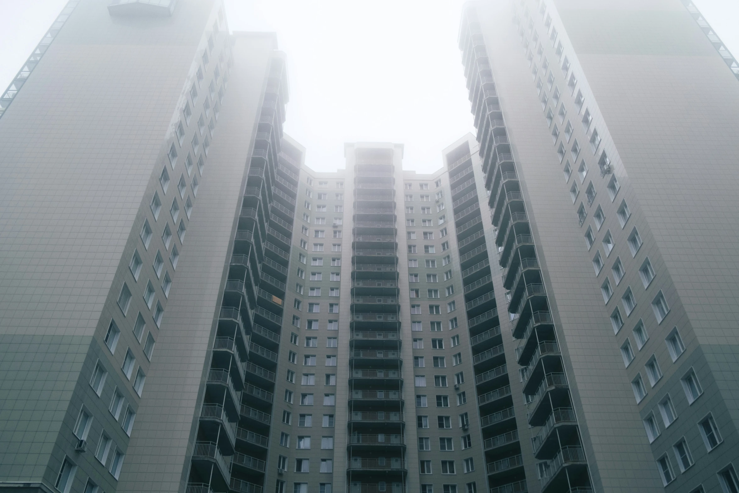 two high rise buildings on the right and another two, which has balconies, are in front of each other