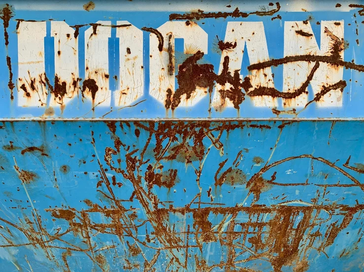 an old and rusty sign on the side of a building