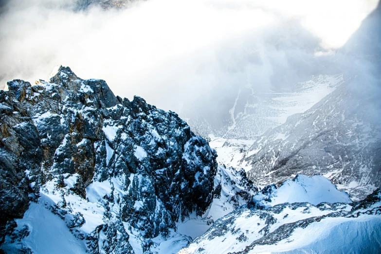 snow covered mountains surround a vast expanse of clouds