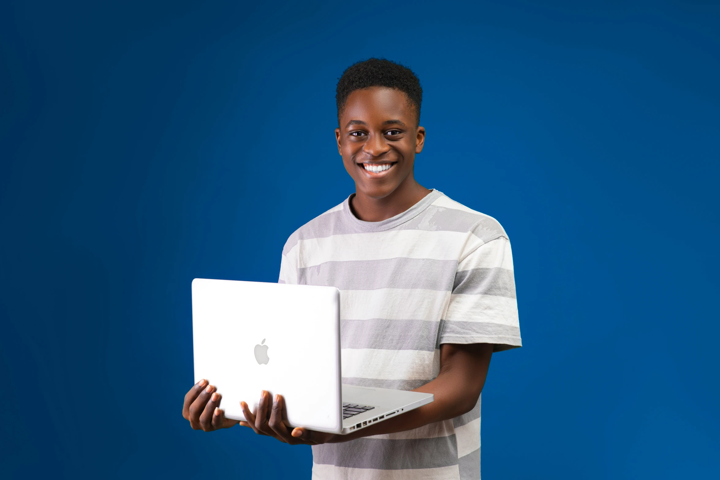 a man holding a apple laptop on his lap