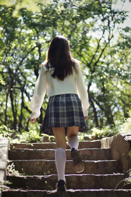 a woman walking up some steps with a skirt and socks